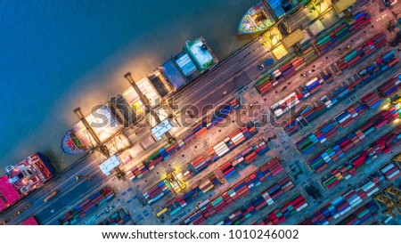 Logistics and transportation of Container Cargo ship and Cargo plane with working crane bridge in shipyard at sunrise, logistic import export and transport industry background