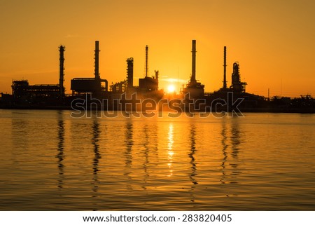 Oil and gas industry - refinery at sunrise - factory - petrochemical plant with reflection over the river