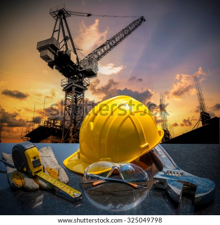 Safety gear kit and tools standing in front of construction site background concept