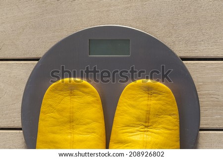 Pair  of slippers  on weight scale, symbol for controlling the weight