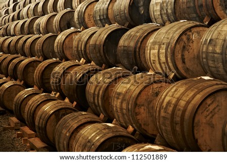 Wine barrels stacked in the old cellar of the winery.