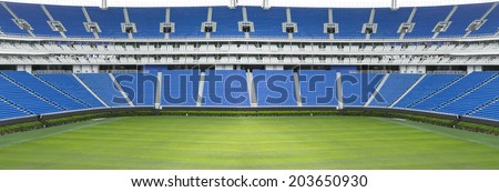 Panoramic football stadium with green grass and blue seats Panoramic football stadium with green grass and blue seats