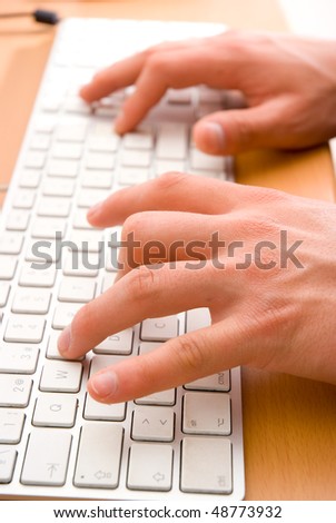 Close-up of man\'s hand touching computer keys during work