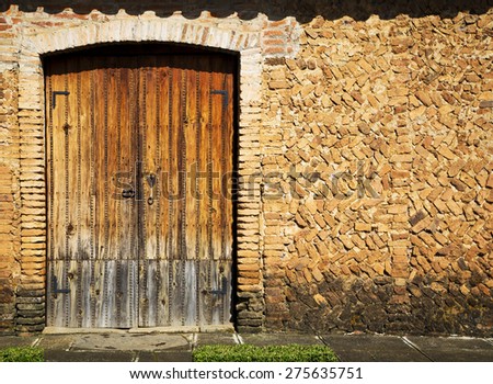 Grunge stile of brick wall and wood door vintage in old town on Mexico.
