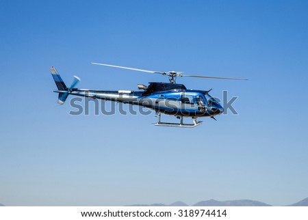 Helicopter in flight. Fly over the mountain and blue sky.