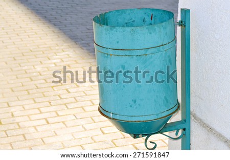 Closeup of a blue trash can on the street in pastel colors