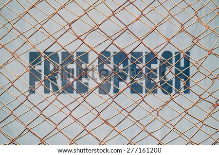 Concept about the rights to free speech with text written under a wire fence