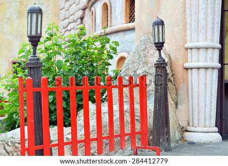Red wooden fence on the entrance of children playground