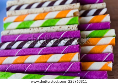 wafer rolls filled with meat obviously purple and yellow on wooden table.