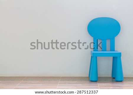 chair on wall background, simple interior with a yellow stool and copy space on the wall