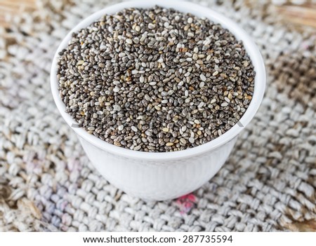 chia seeds in cup on sack, closeup chia seeds,