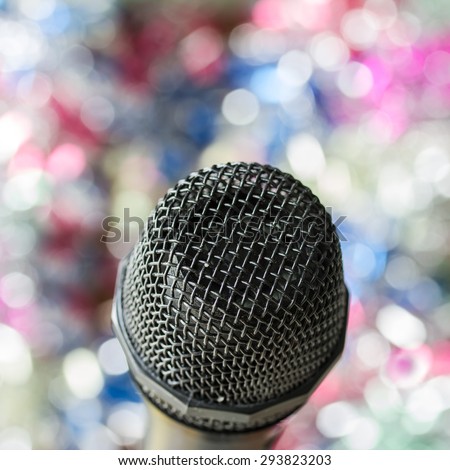 Close up of microphone in concert hall or conference room with lights in background