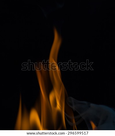 Yellow fire flames, isolated on black background, smoke on black background,