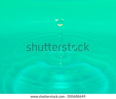 defocus green water drop falling down.