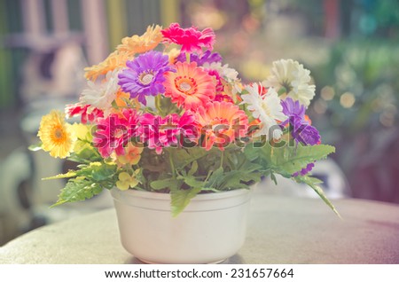 Beautiful flowers in a vase on a wooden table in vintage style.
