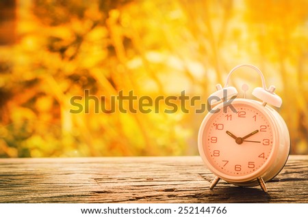 Vintage background with retro alarm clock on wooden table. black and white