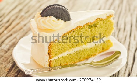 Green tea cream vanilla cake on wooden background soft focus vintage tone.