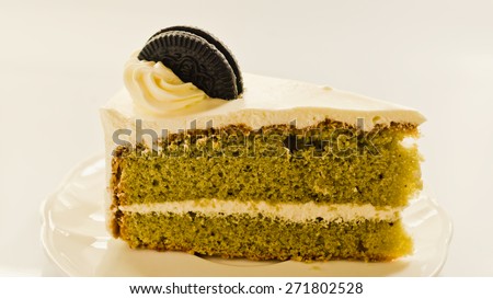 Green tea with vanilla cream cake on white background soft focus.