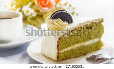 Green tea with vanilla cream cake and cup of coffee on white background soft focus.