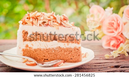 Almonds chocolate cake on wooden background soft focus vintage tone.
