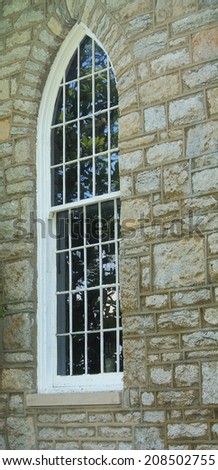 Window of an old church, surrounded by old rocks and bricks.