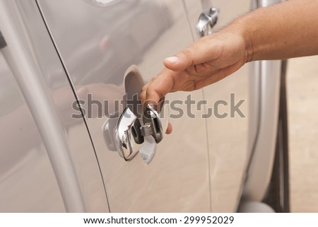 Close up of a man opening a car door in a garage