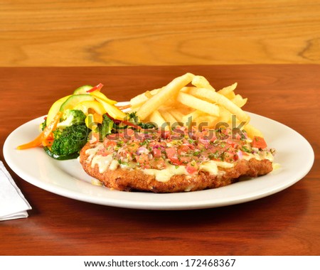 Breaded meat with melted cheese and salad topping.