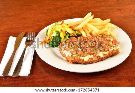 Breaded meat with melted cheese and salad topping.