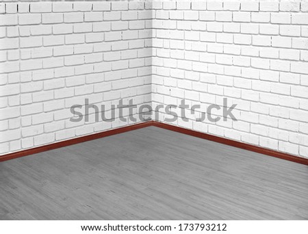 Brick wall on hardwood floor. Empty room.