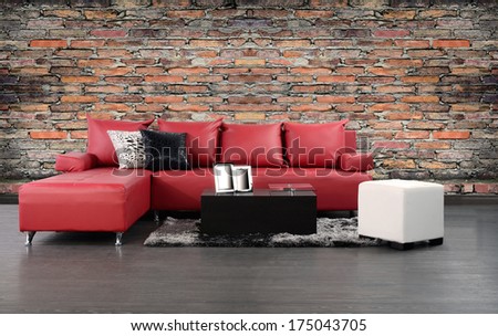 Living room. Furniture on hardwood floor against rough brick wall.