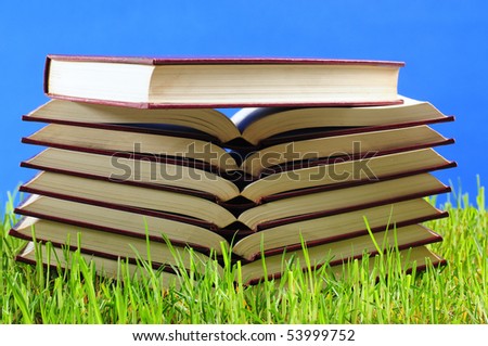 Books on bright grass. Educational concept.