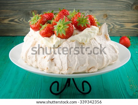Pavlova cake with strawberry on rustic background