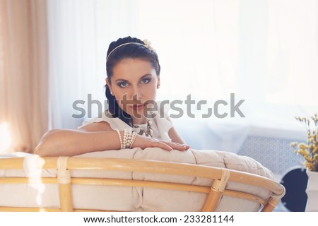 Happy pretty brunette young woman resting at home in a comfortable chair.
