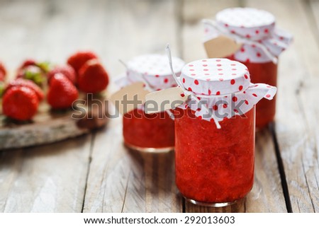 Fresh strawberry homemade jam in jar on wood background. healthy organic and vegan food.