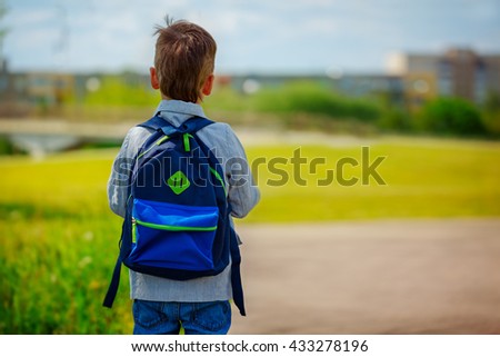 Little boy with a backpack go to school. Back view.