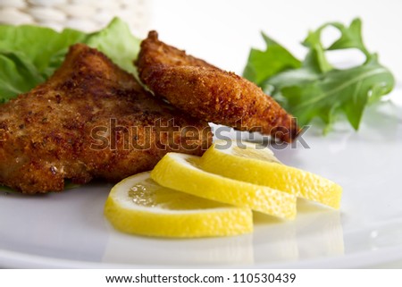 Breaded meat with lemon and salad