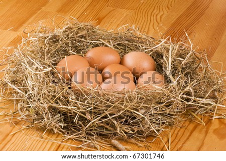 Fresh farm eggs in hay on wooden table
