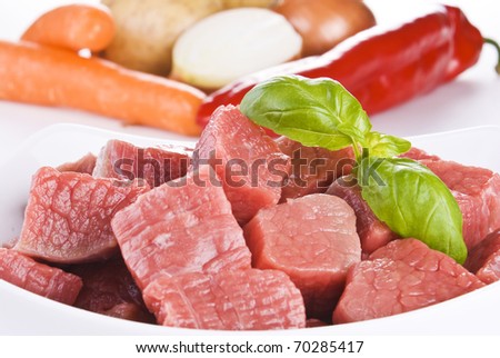Close up of diced beef with vegetables over white background