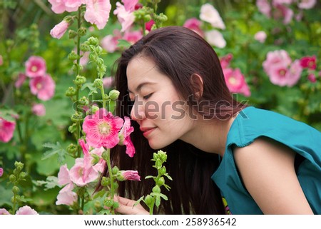 girl is smelling the flower among the sunshine in the morning