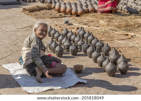 BHAKTAPUR, NEPAL - DEC 2, 2013: an unidentified elderly woman ask for charity on December 2, 2013 in Bhaktapur, Kathmandu Valley, Nepal