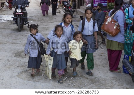 PANAUTI, NEPAL - DEC 2: five poor unidentified children come home after school with the modest and dirty uniform of the public school on december 2, 2013 in Panauti. Panauti is a historical city in Nepal.