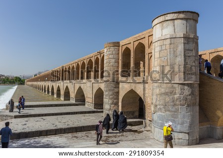 ISFAHAN, IRAN - APRIL 28, 2015: unidentified people resting in the ancient bridge Si-o-Seh Pol, The Bridge of 33 Arches, in Isfahan, Iran