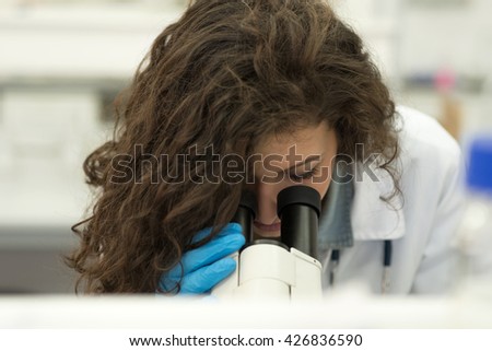 young student working with a microscope