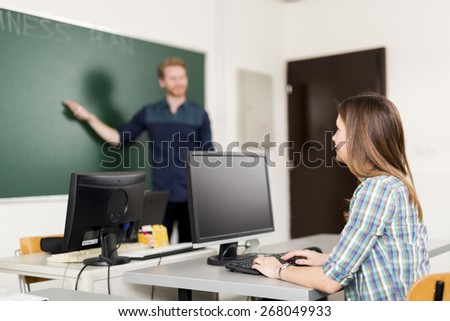 Teacher educating a pupil in a classroom who is paying close attention