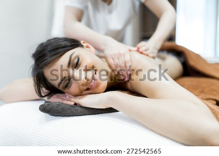 Beautiful woman lying on a massage table and relaxing while being massaged