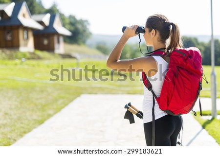 Portrait of a hiker woman using binoculars as she checks out the landscape