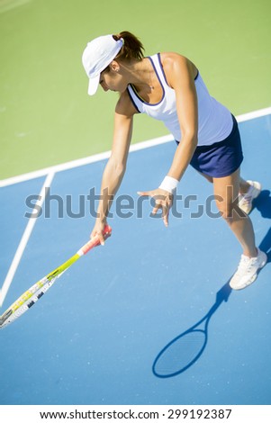 Beautiful female tennis player in action, hitting a forehand