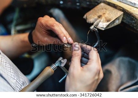 Jeweler making jewelry on workbench