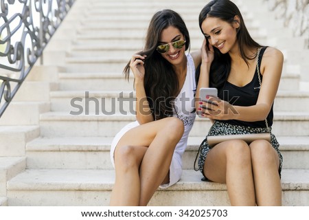 Beautiful women looking at phone and smiling while reading the contents