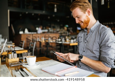 Businessman holding tablet in cafe